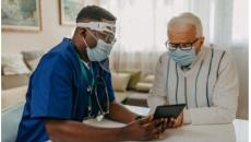 Healthcare worker in mask talking to patient in mask