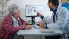 Doctor showing medical data on a screen to a patient 