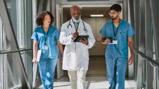 Healthcare workers walking with doctor in hospital hallway