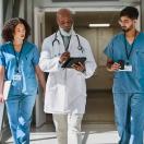 Healthcare workers walking with doctor in hospital hallway