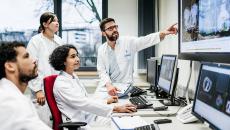 Healthcare workers looking at a medical image on a monitor