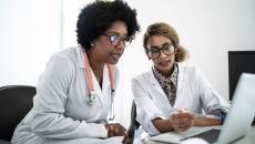 Two health professionals at a laptop