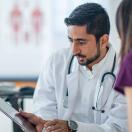 Doctor showing tablet to a patient