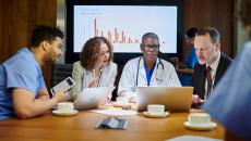 Medical professionals meeting with a graph in the background