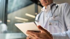 A doctor reviewing a patient's record on a digital tablet