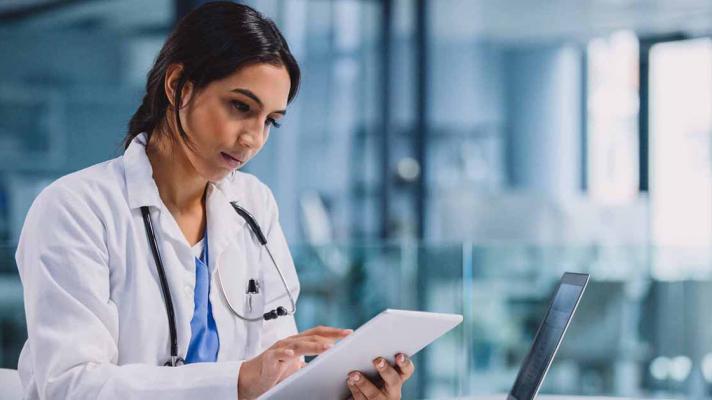 Doctor using tablet and laptop