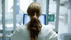 Doctor with long hair at laptop