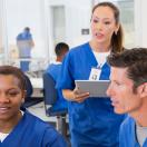 Nurses talking while looking at computer screen