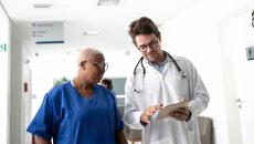 Doctor showing tablet to healthcare worker