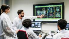 Healthcare worker pointing at medical image on a display to coworkers