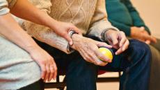 A patient's hand squeezes a stress ball in a hospital waiting room