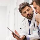 Doctor showing tablet to patient