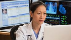 A doctor checking a patient's record on a laptop computer