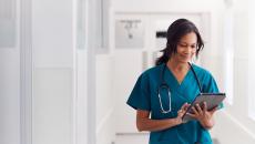 A doctor checking a patient record on their digital tablet.