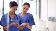 Nurses looking at a patient's medical record on a digital tablet